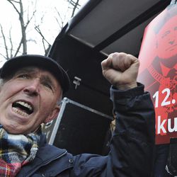A man shouts slogans as anti-government protesters gather in front of the Constitutional Court to thank the outgoing head of court Andrzej Rzeplinski seen on the placard, for his efforts to defend its independence, in Warsaw, Poland, Sunday, Dec. 18, 2016.  