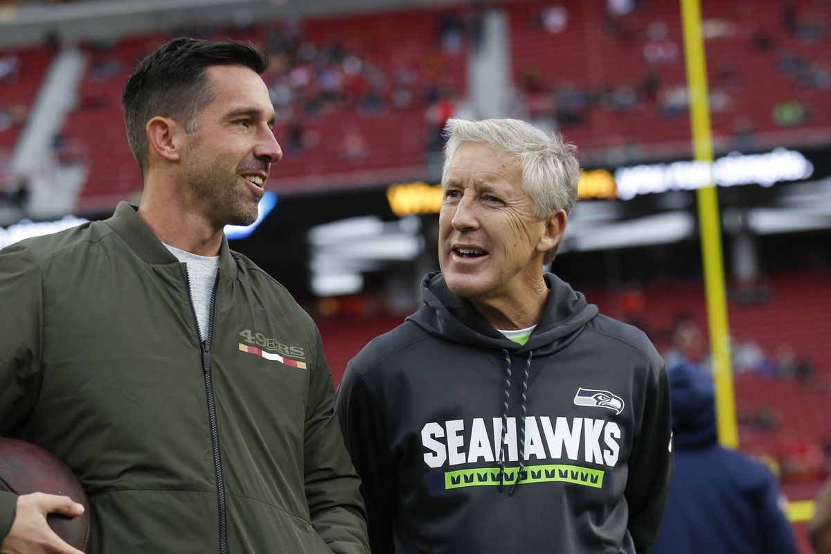 Seattle Seahawks head coach Pete Carroll and San Francisco 49ers head coach Kyle Shanahan chatting before a game.