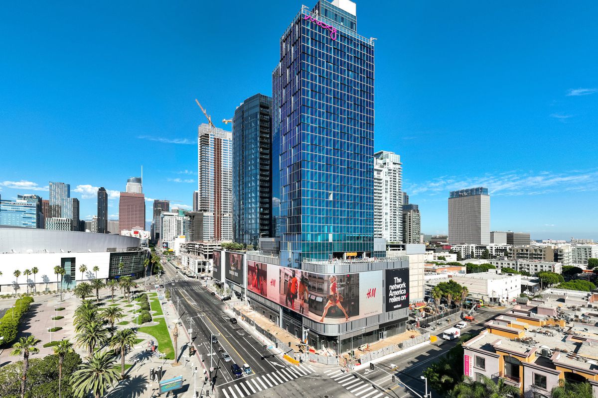 A sky-level view of an under-construction glassy hotel on a sunny day in Los Angeles, California.