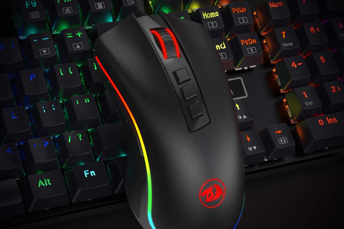 A rainbow-backlit gaming keyboard with a mouse lying on top of it