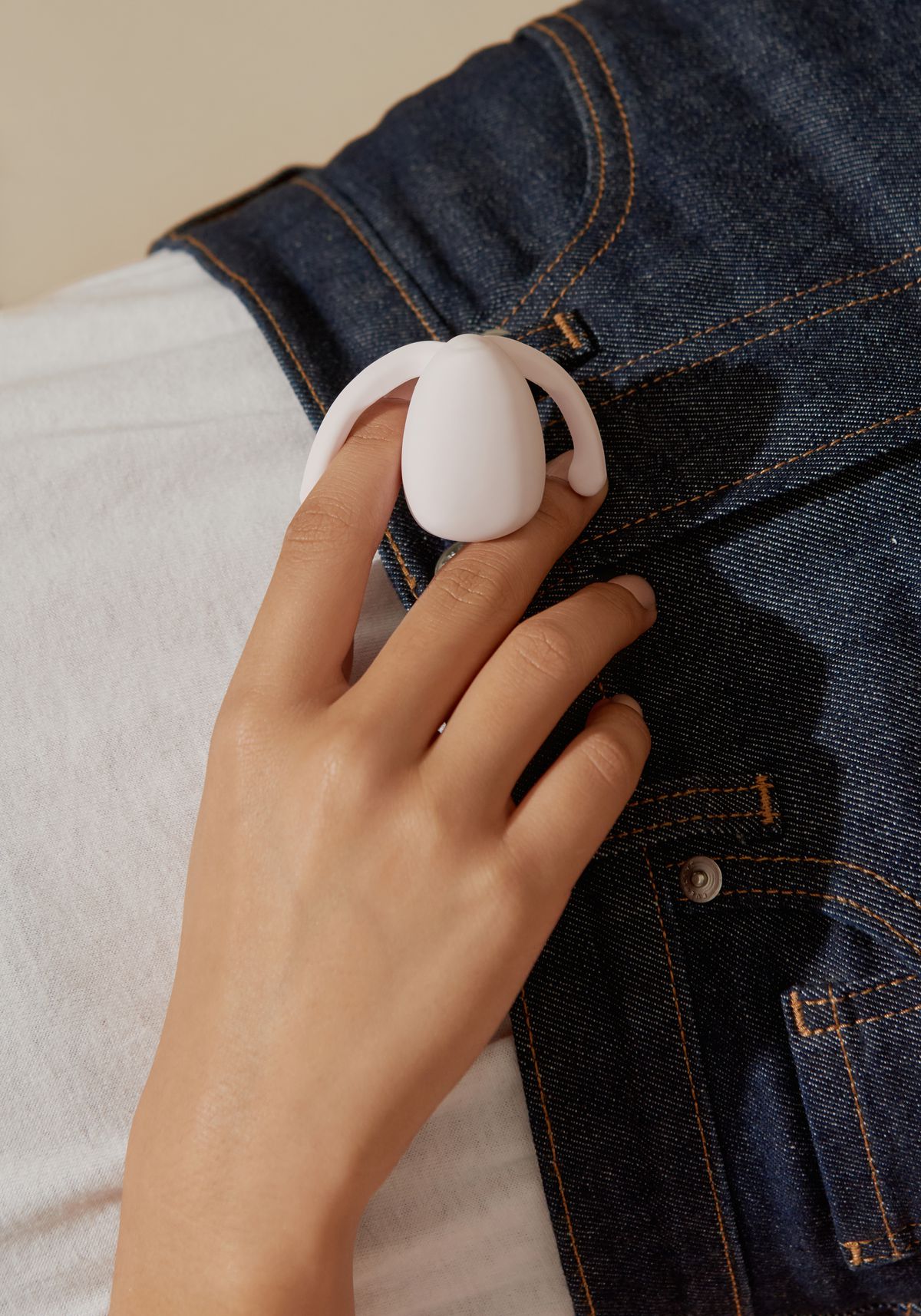 A woman wearing jeans holding an egg shaped vibrator