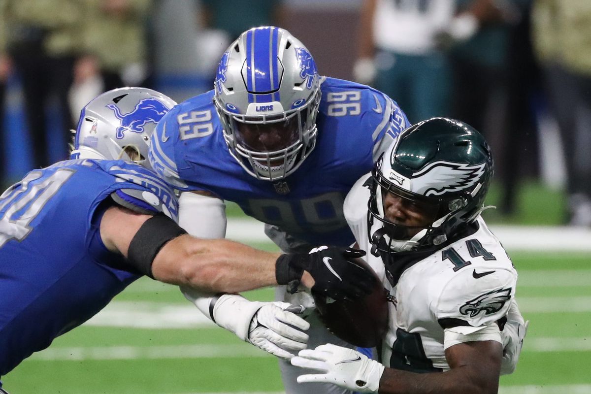 Detroit Lions inside linebackers Alex Anzalone (34) and Julian Okwara (99) tackle Philadelphia Eagles running back Kenneth Gainwell (14) during second half action at Ford Field Sunday, Oct. 31, 2021.