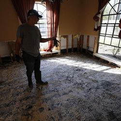 Sam Montes looks over his front room after volunteers removed drywall after Tropical Storm Harvey in Spring, Texas, on Thursday, Aug. 31, 2017.