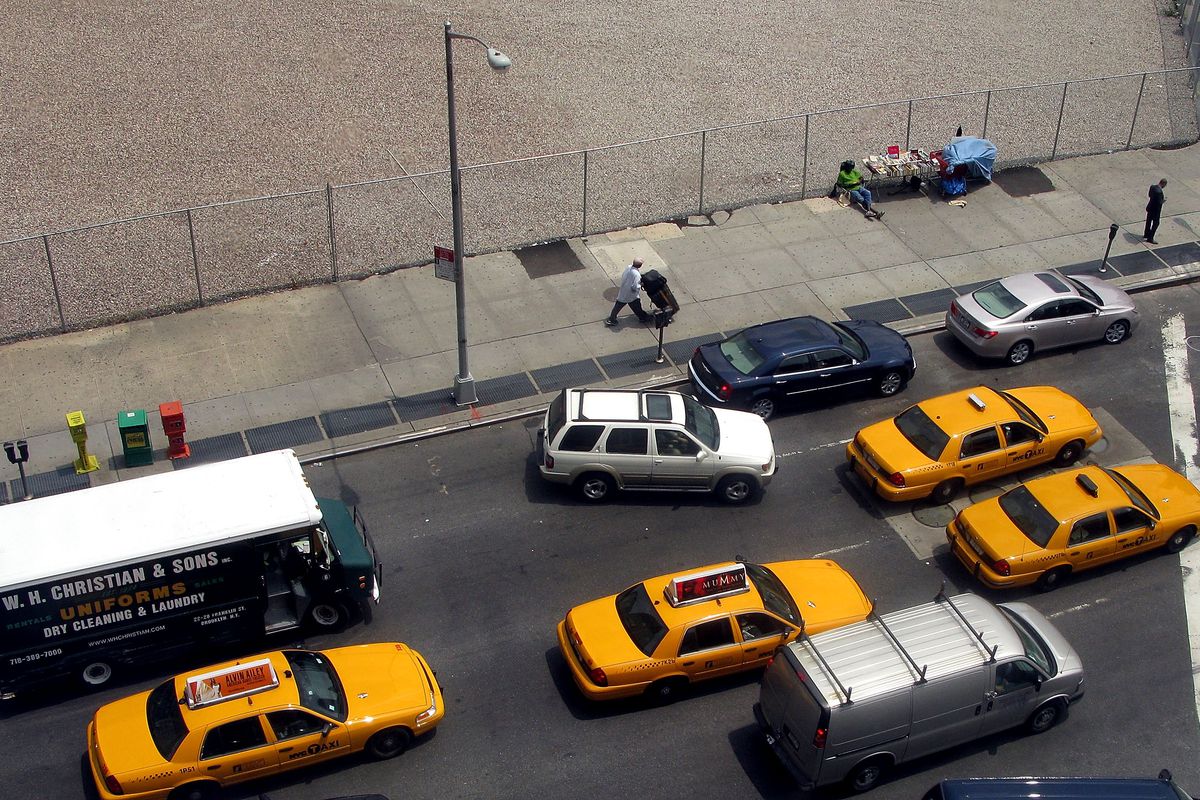 Taxis and cars, shown from above, drive on a New York street.
