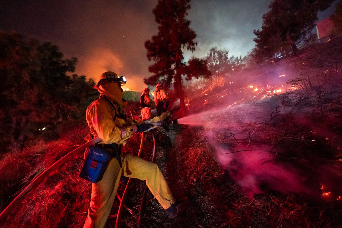 Firefighters work to put out a fire near Getty Center in Los Angeles.