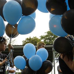 Chance Haan, 10, the younger brother of Maddison Haan, 20, holds balloons during a vigil in Roy on Friday, July 1, 2016. The vigil was for Tyler Christianson, 19, and Haan, 20, who died while driving after being hit by Marilee Patricia Gardner, 16, who was going 100 mph and who police say was attempting to commit suicide.