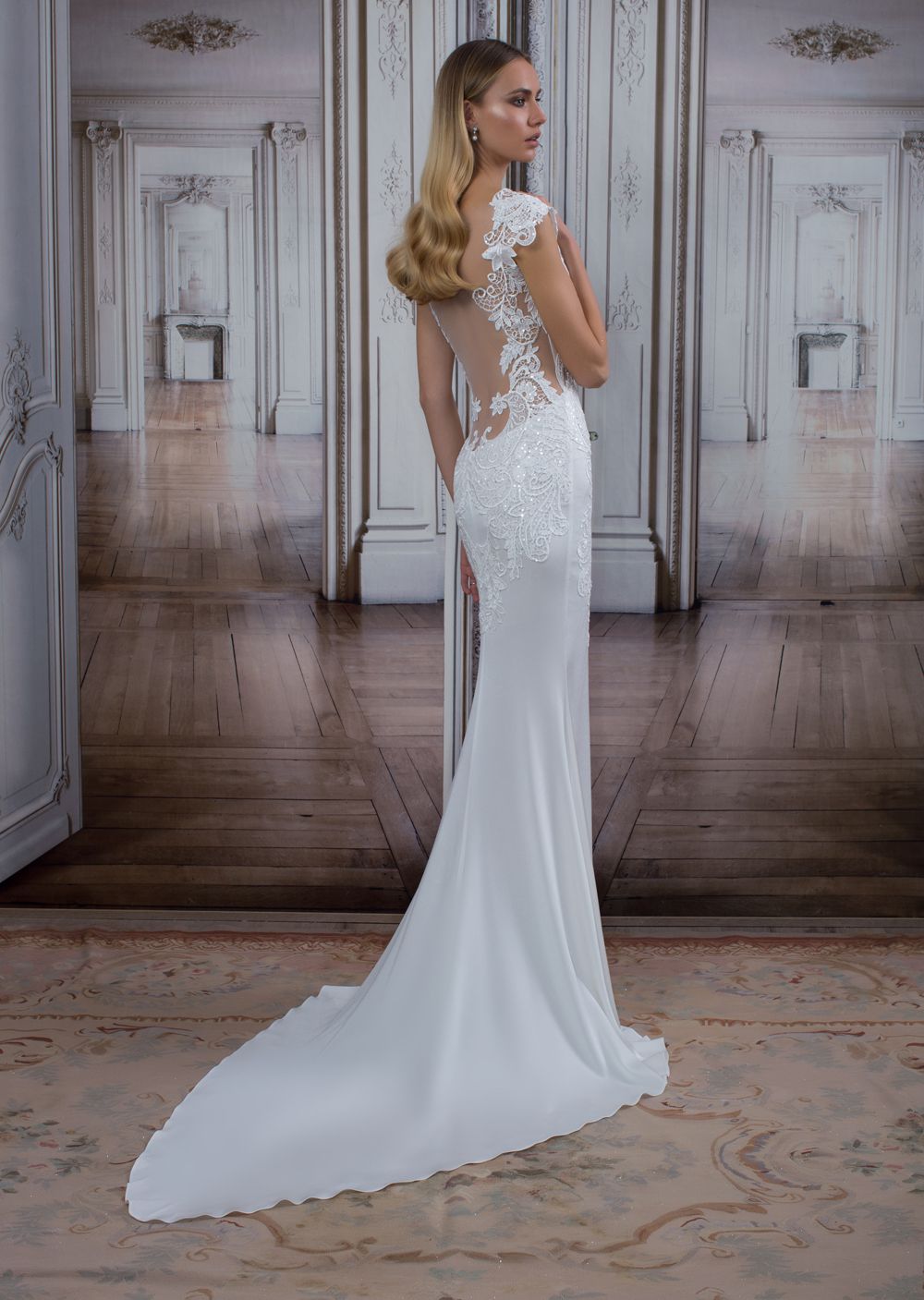 A model wearing a detailed wedding gown with a lace back
