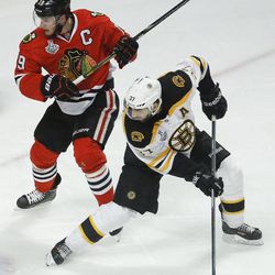 Boston Bruins center Patrice Bergeron (37) looks for a rebound against Chicago Blackhawks center Jonathan Toews (19) in the first period during Game 5 of the NHL hockey Stanley Cup Finals, Saturday, June 22, 2013, in Chicago. Bergeron left the game in the second period with an injury and did not return. (AP Photo/Charles Rex Arbogast)