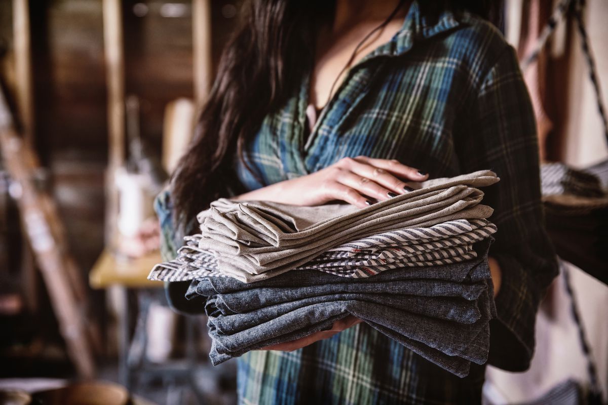 A woman holding a stack of fabric