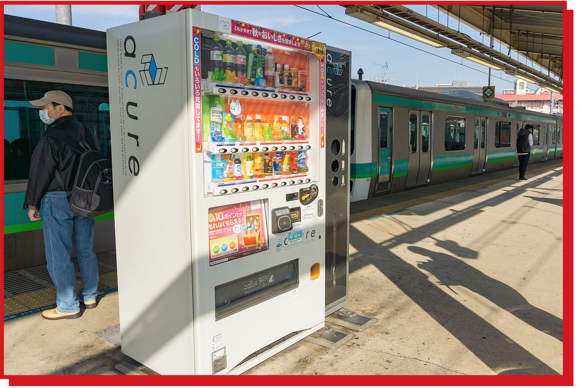 Vending machines containing drinks sit on an above ground train platform in Japan.