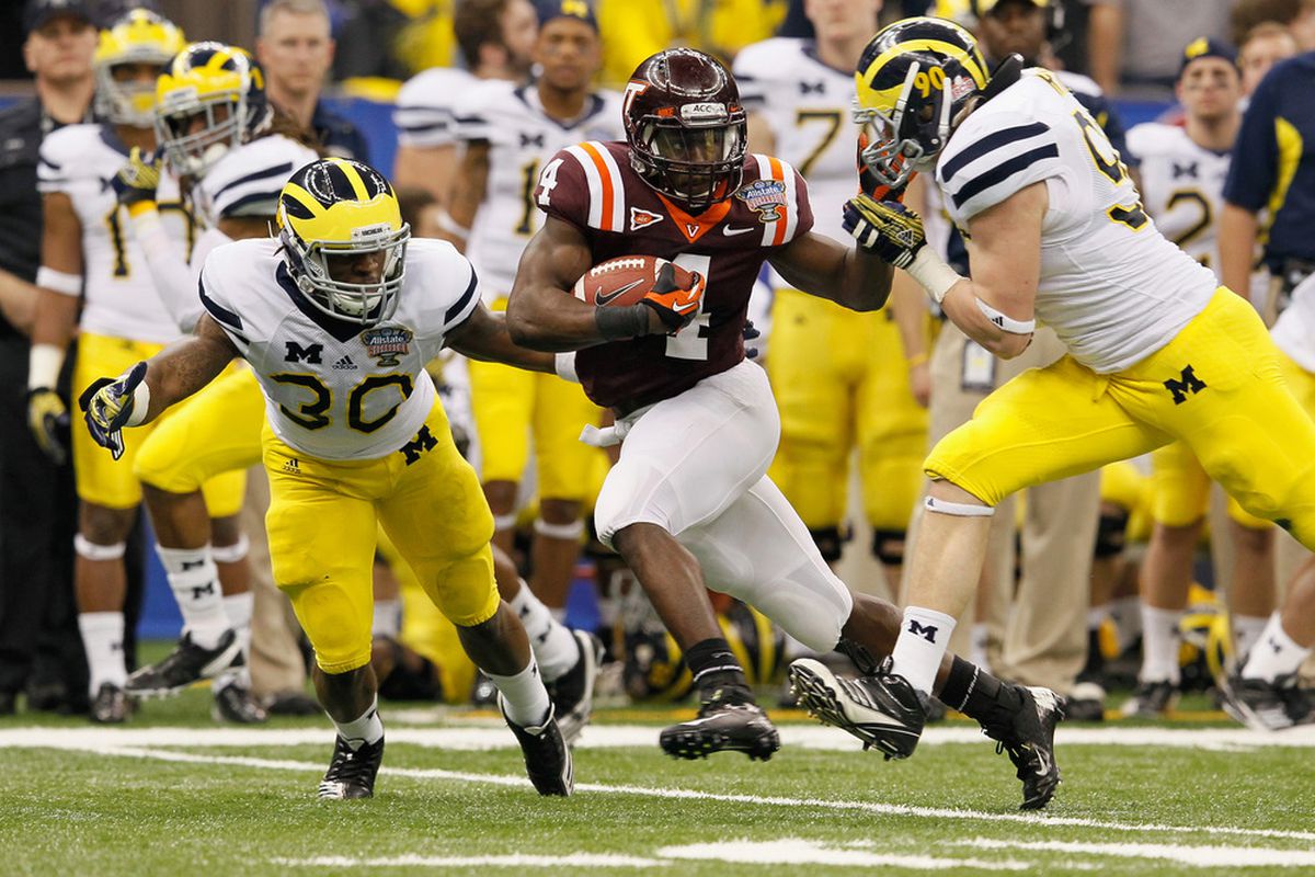 David Wilson #4 of the Virginia Tech Hokies runs the ball against Thomas Gordon #30 and Jake Ryan #90 of the Michigan Wolverines in the second quarter during the Allstate Sugar Bowl.