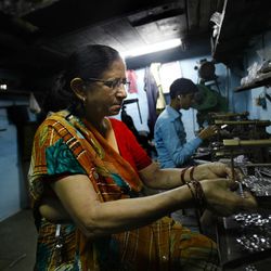 In this Monday, May 20, 2013 photo, Shanti Devi Maurya, who was suffering from cervical cancer, works at her workshop in a slum in Mumbai, India. Maurya is one of women in Mumbai's slums who were part of a 12-year-long study by the city's Tata Memorial Hospital to see how a simple test using a swab of acetic acid or household vinegar could detect cervical cancer and reduce India's large death toll from that disease. The simple vinegar test slashed cervical cancer death rates by one-third in a remarkable study of 150,000 women in the slums, where the disease is the top cancer killer of women. 