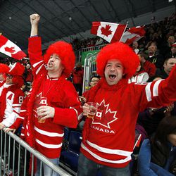 Cory Caouette, right, and Jim Dunn, of Devon, Alberta, Canada, cheer for the home team in a women's curling match against Denmark at the Vancouver 2010 Olympics in Vancouver, British Columbia, Friday.