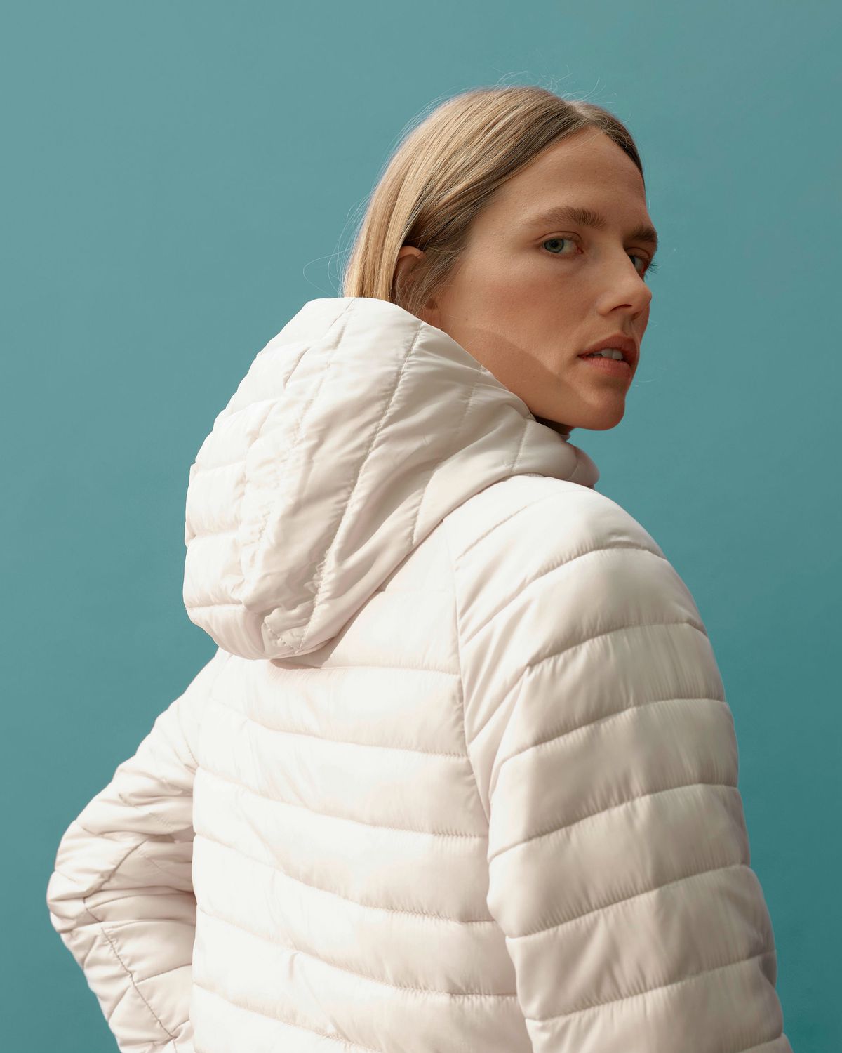 A model wears a white Everlane puffer jacket.