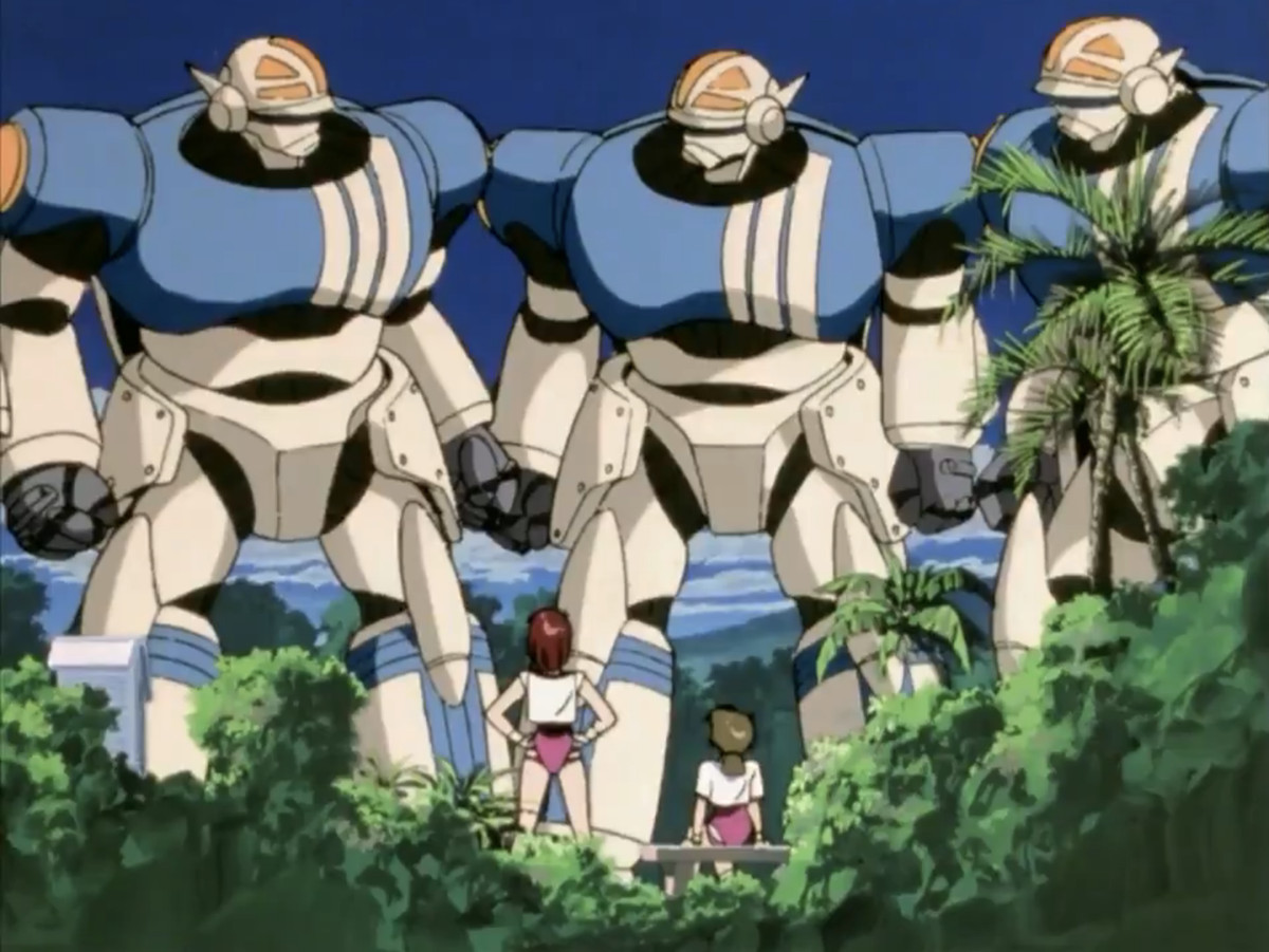 Noriko and her friend stand in their gym clothes looking up at three mechas in a screenshot from Gunbuster