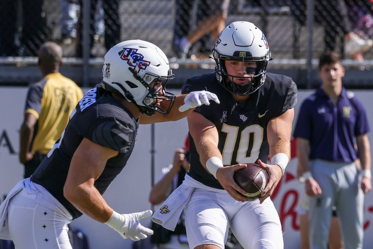 UCF Knights quarterback John Rhys Plumlee fakes a hand off to UCF Knights running back Isaiah Bowser during the first quarter at FBC Mortgage Stadium.
