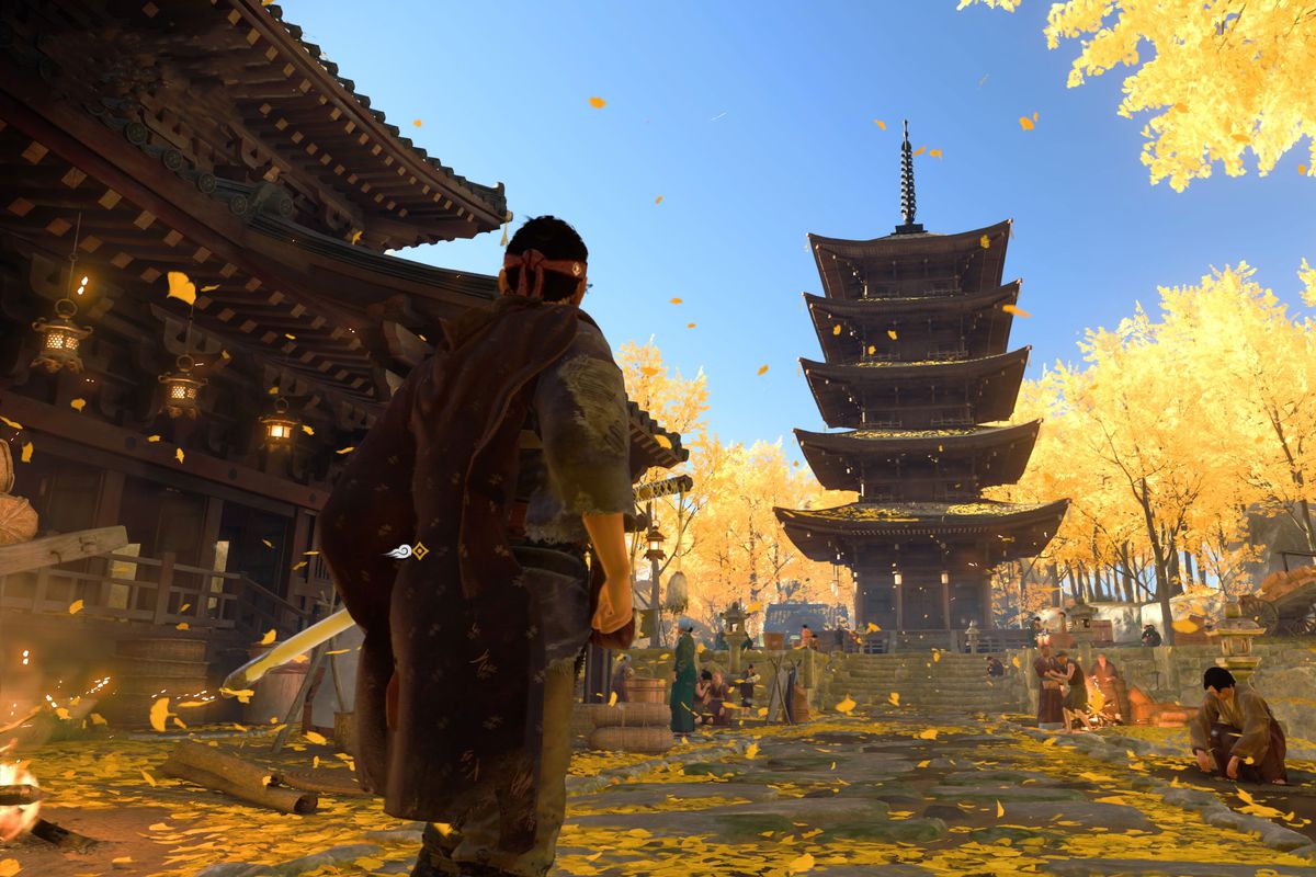 Ghost of Tsushima’s main character standing in a temple with yellow leaves