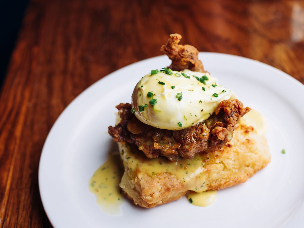 A piece of fried chicken sits on a biscuit with a poached egg perched on top at Blackheart