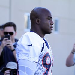 Newly acquired DE DeMarcus Ware makes his way past the media onto the practice field.