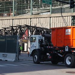 Waste hauler pulling in on Addison Street, to haul away the Draft Kings Sports Zone debris