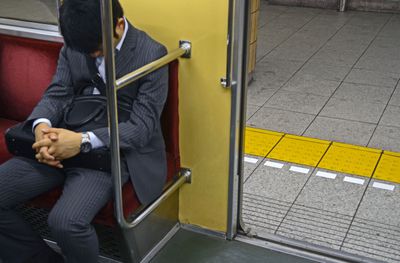 Businessman sleeping in subway train, Tokyo.