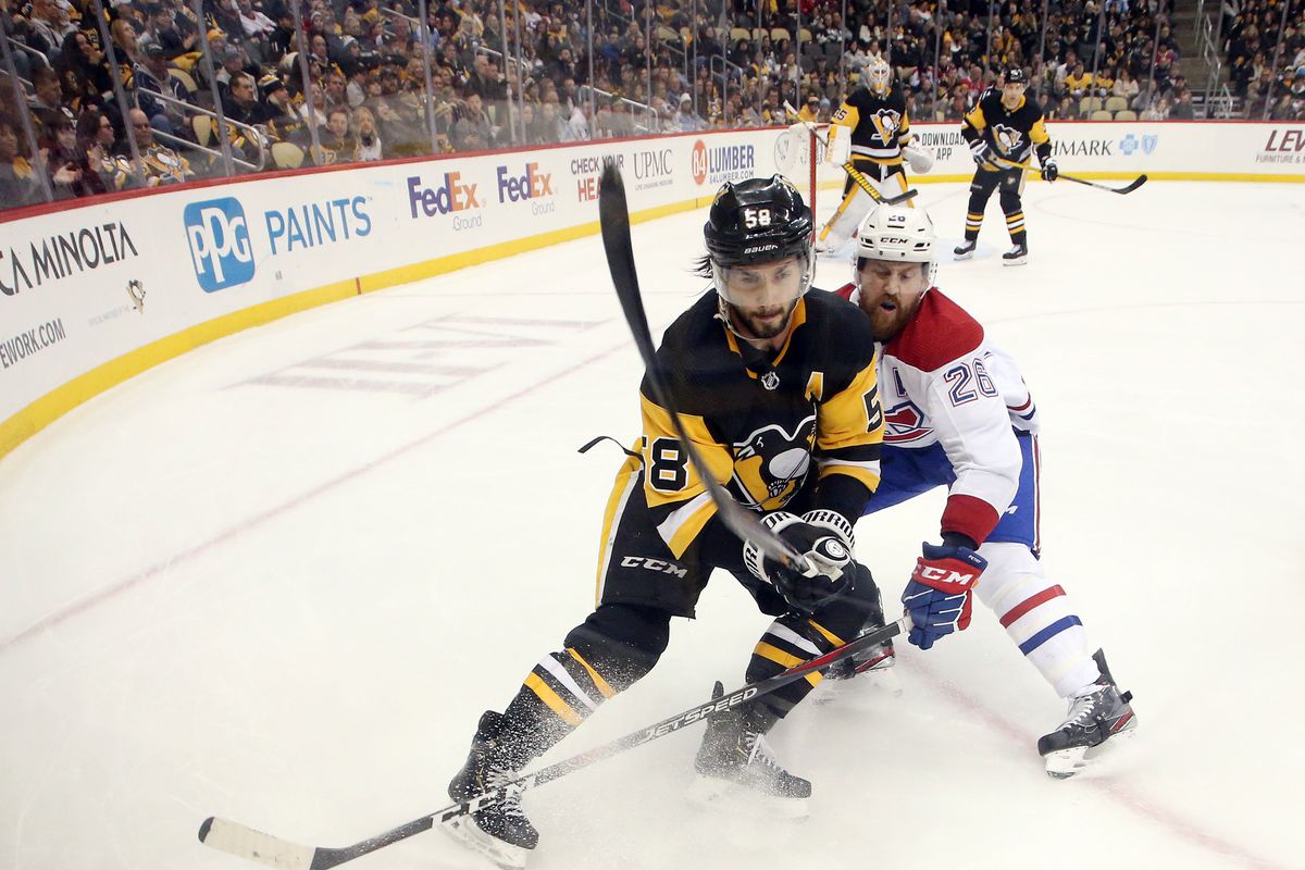 Pittsburgh Penguins defenseman Kris Letang chases the puck against Montreal Canadiens defenseman Jeff Petry during the third period at PPG PAINTS Arena.