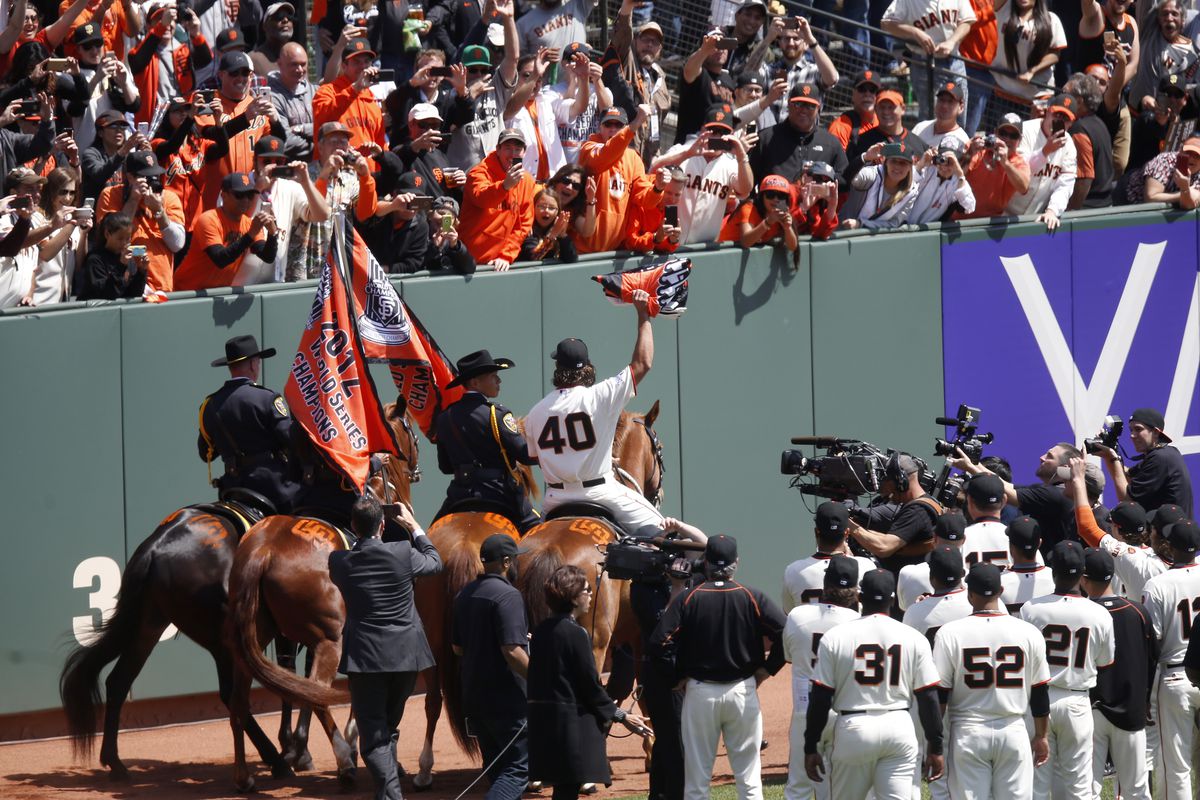 San Francisco Giants starting pitcher Madison Bumgarner (40) raises the championship banner after mounting a horse on his way to deliver the banner to center centerfield before their home opener against the Colorado Rockies at AT&amp;T Park in San Francisco,