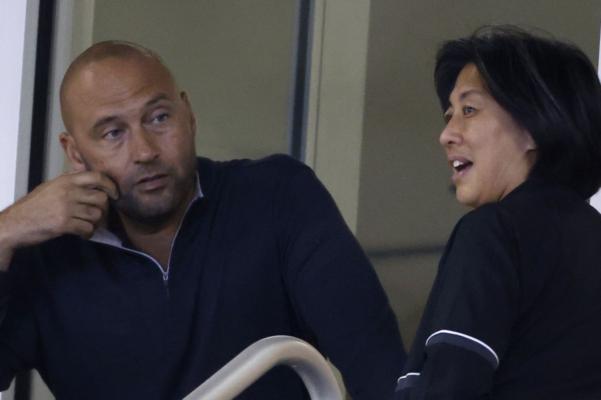 CEO Derek Jeter of the Miami Marlins talks with general manager Kim Ng during the seventh inning against the New York Mets at loanDepot park