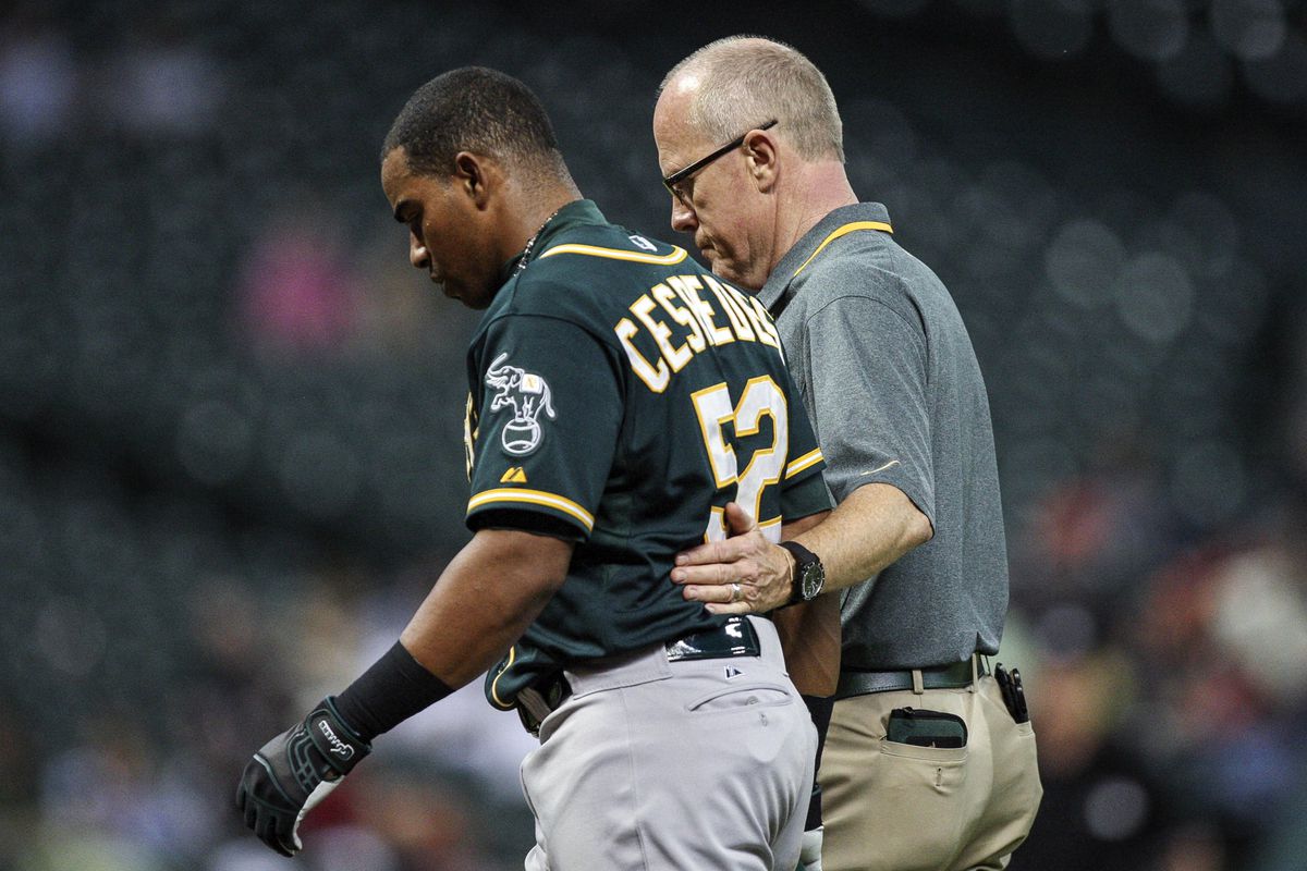 The trainer isn't helping Cespedes, he's holding him back so that he won't sprint into the clubhouse.