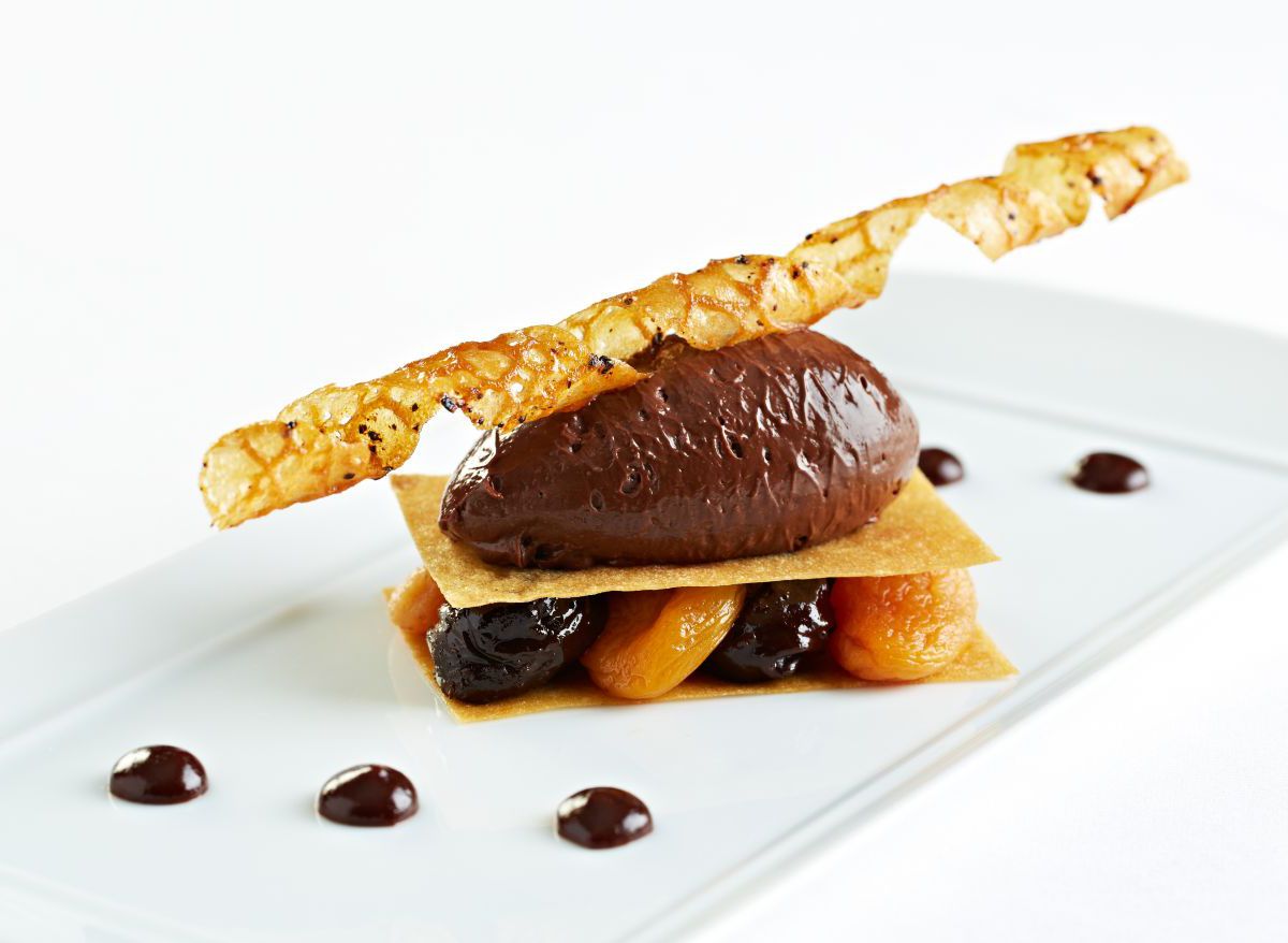 An ornate dessert centered around a large scoop of cacao ice cream.
