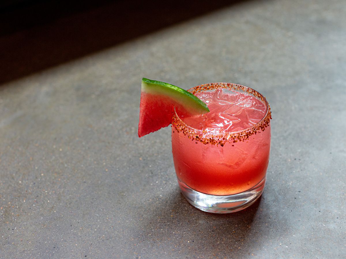 A cocktail glass lined with chili salt and a piece of watermelon as a garnish.