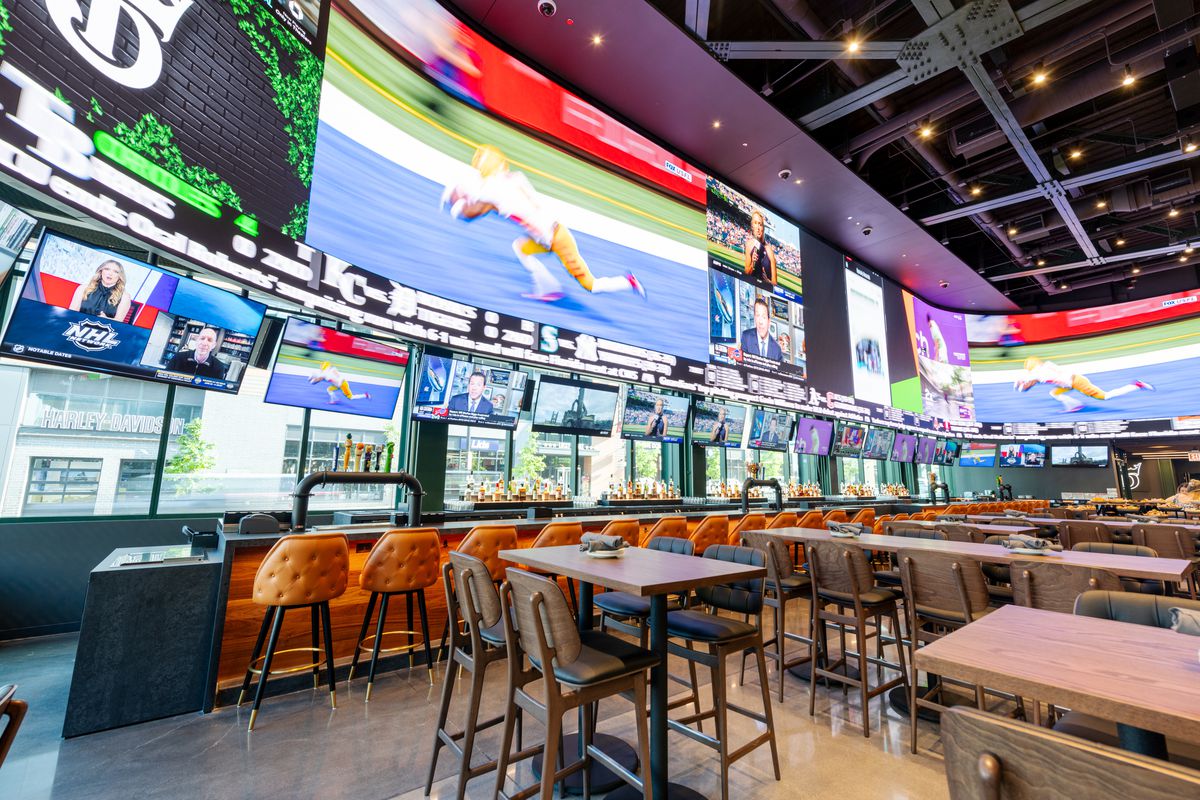 A long bar space with walls entirely covered in TV screens.