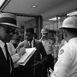 Roy Wilkins, left, executive secretary of the NAACP, and Medgar Evers, center, field secretary of the NAACP are arrested for picketing, June. 1, 1963 in downtown Jackson, Mississippi.