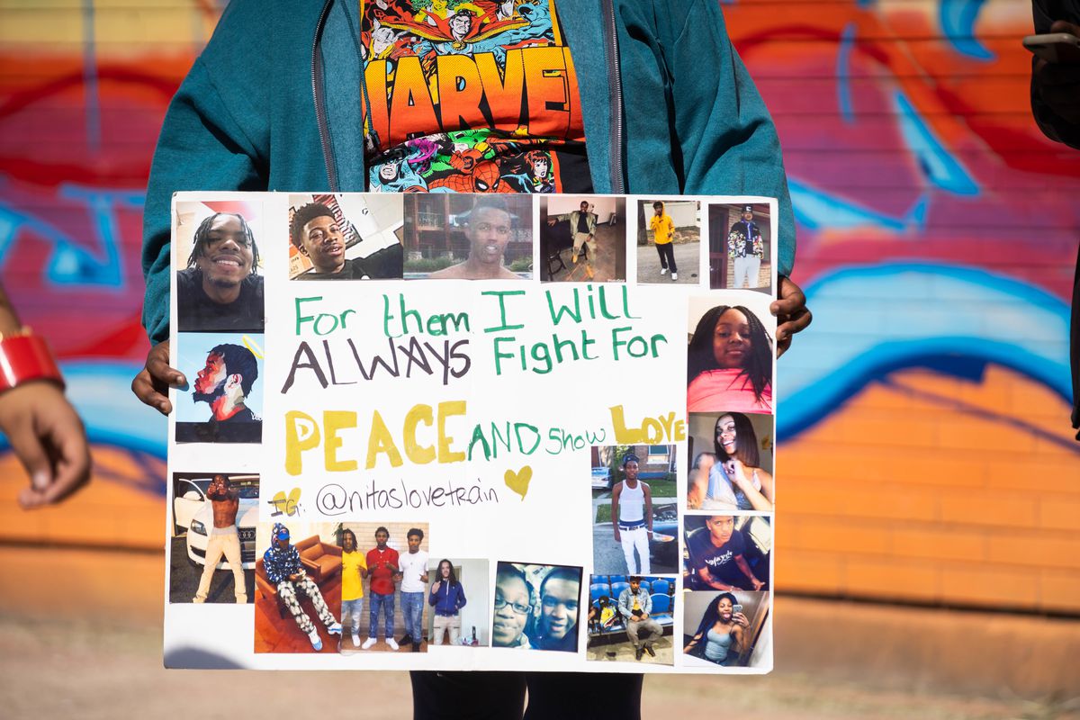 Nita Tennyson holds a collage of pictures of friends she has lost to gun violence at the Peace Walk & Community Give-Back Celebration Saturday outside Overton Elementary School in Bronzeville.