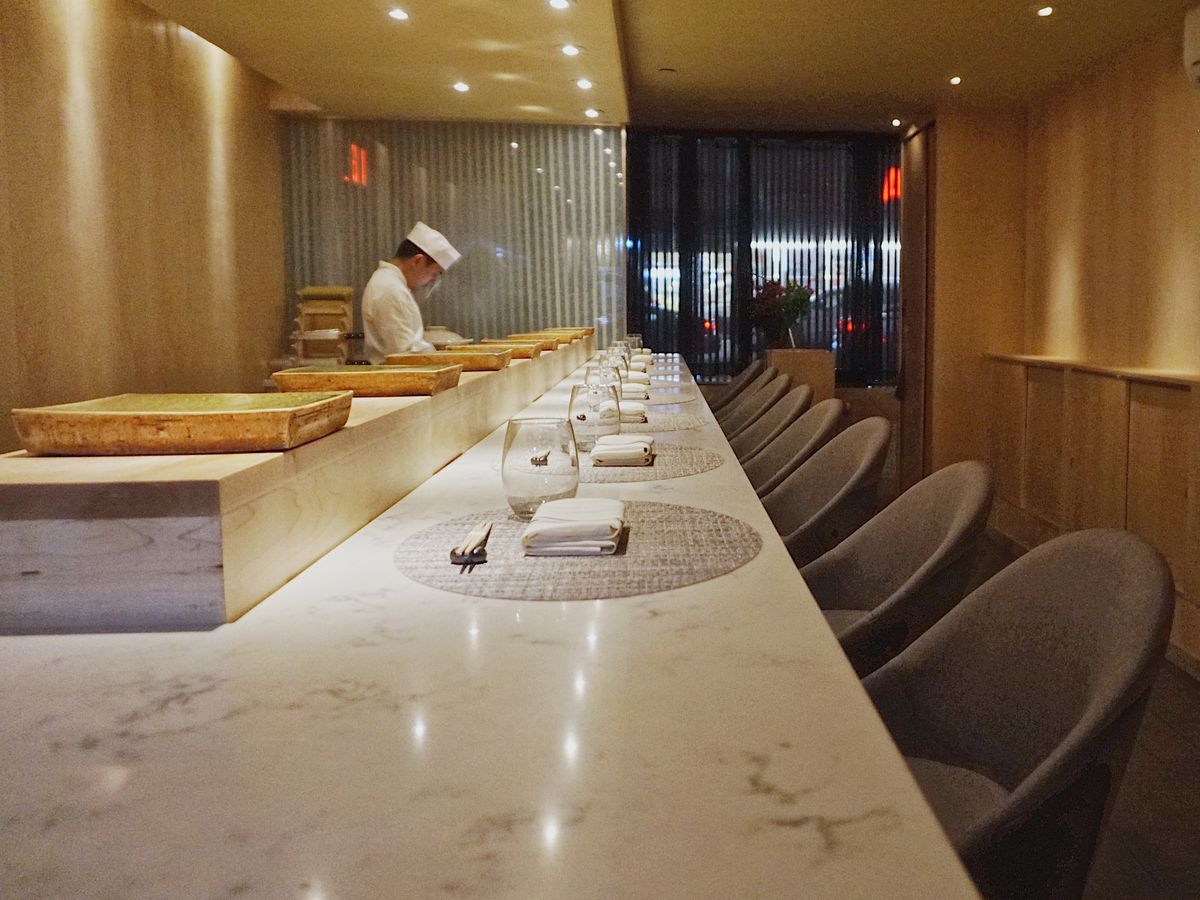 The bar at Koyo which features a marble countertop and oval shaped chairs placed against it