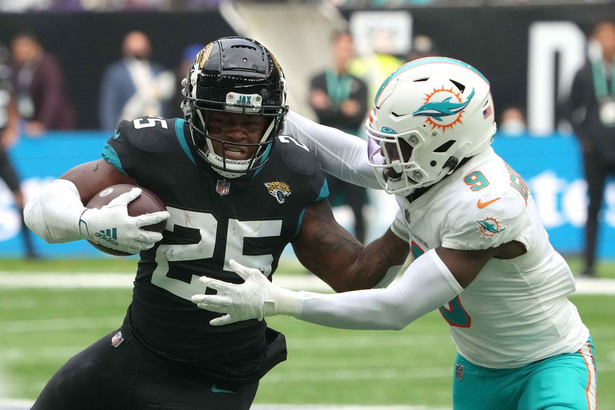 Jacksonville Jaguars running back James Robinson (25) is defended by Miami Dolphins cornerback Noah Igbinoghene (9) in the first half during an NFL International Series game at Tottenham Hotspur Stadium.&nbsp;