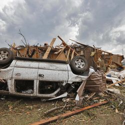 A demolished home with the car flipped over is all that remains left behind in the damage from the tornado that hit the area near 149th and Drexel on Monday, May 20, 2013 in Oklahoma City, Okla. 