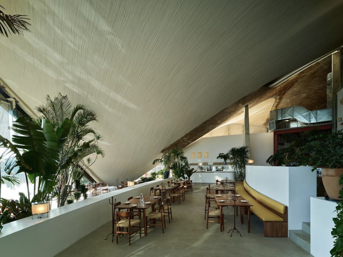 A dining area with a striking curved ceiling.