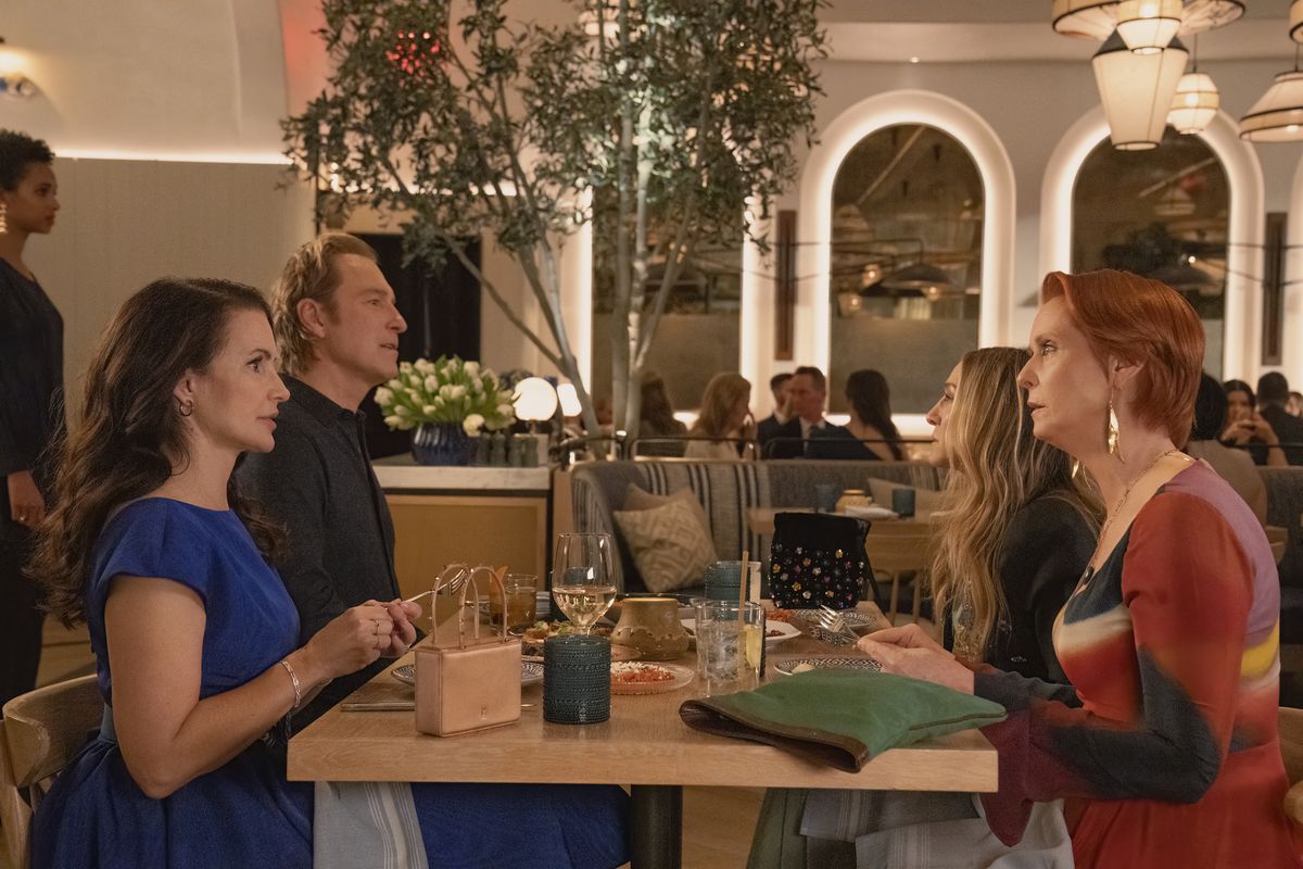 a still image from Season 2 Episode 8 of Max’s And Just Like That showing Carrie, Aidan, Miranda, and Charlotte sitting at a table in the Jose Andres restaurant Zaytinya for dinner