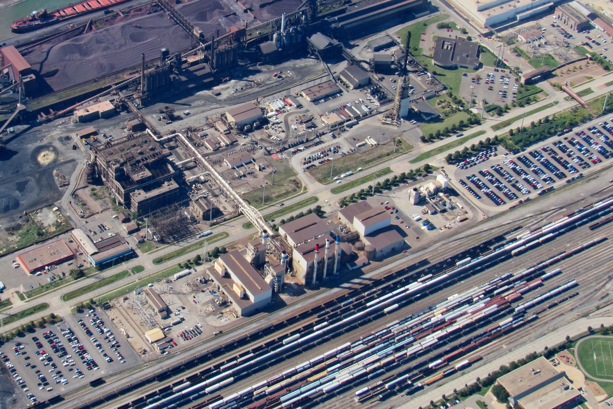 Aerial view of an industrial park with factories and a rail yard. 