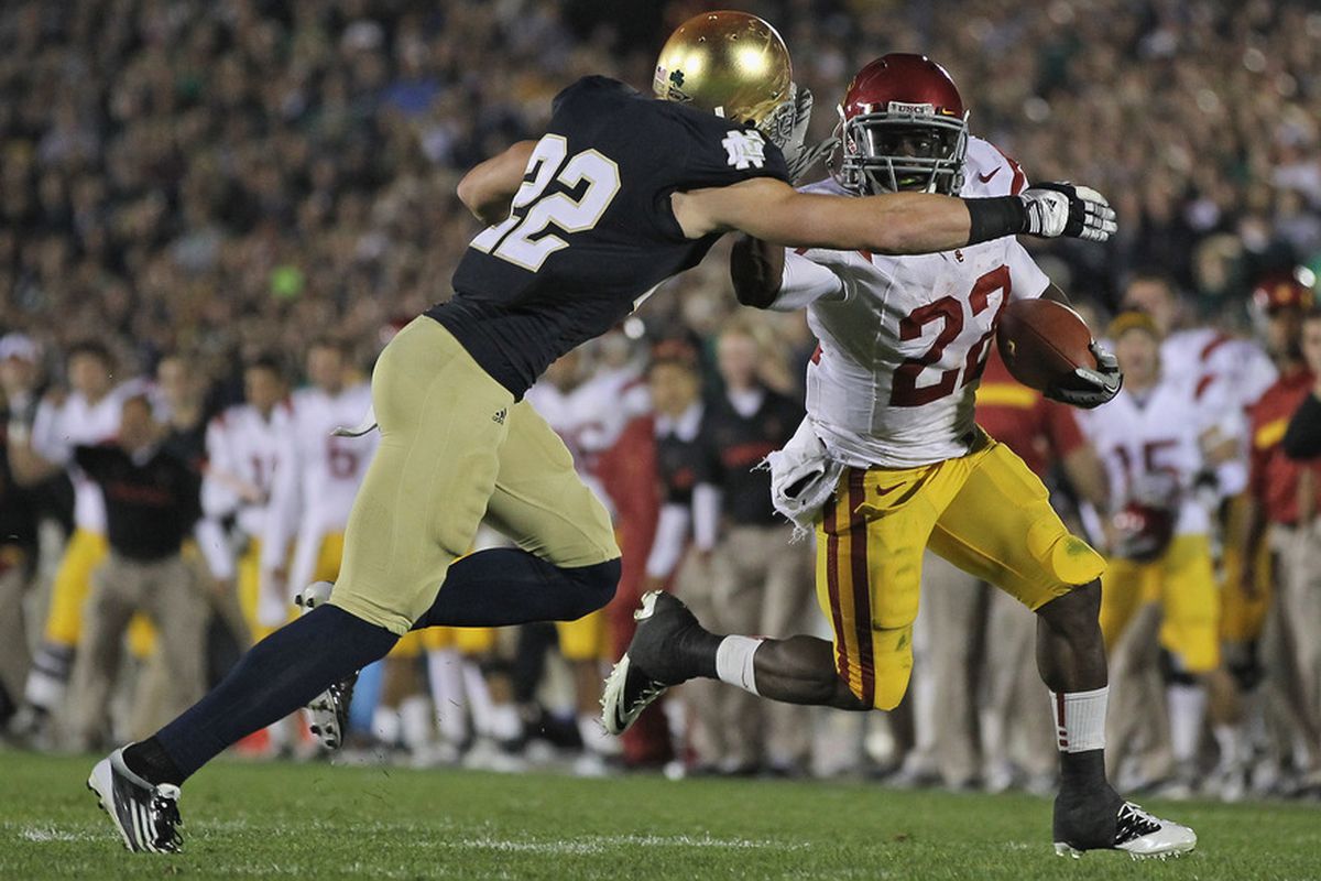Curtis McNeal #22 of the University of Southern California Trojans tries to hold off Harrison Smith #22 of the Notre Dame Fighting Irish.