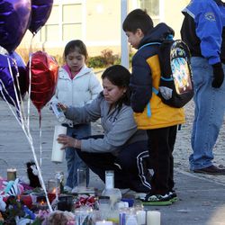 Marbel Campos, her daughter McKenzie and her son Anthony stop at a memorial for Charlie and Braden Powell at Emma L. Carson Elementary School in Puyallup, Wash., Monday, Feb. 6, 2012.