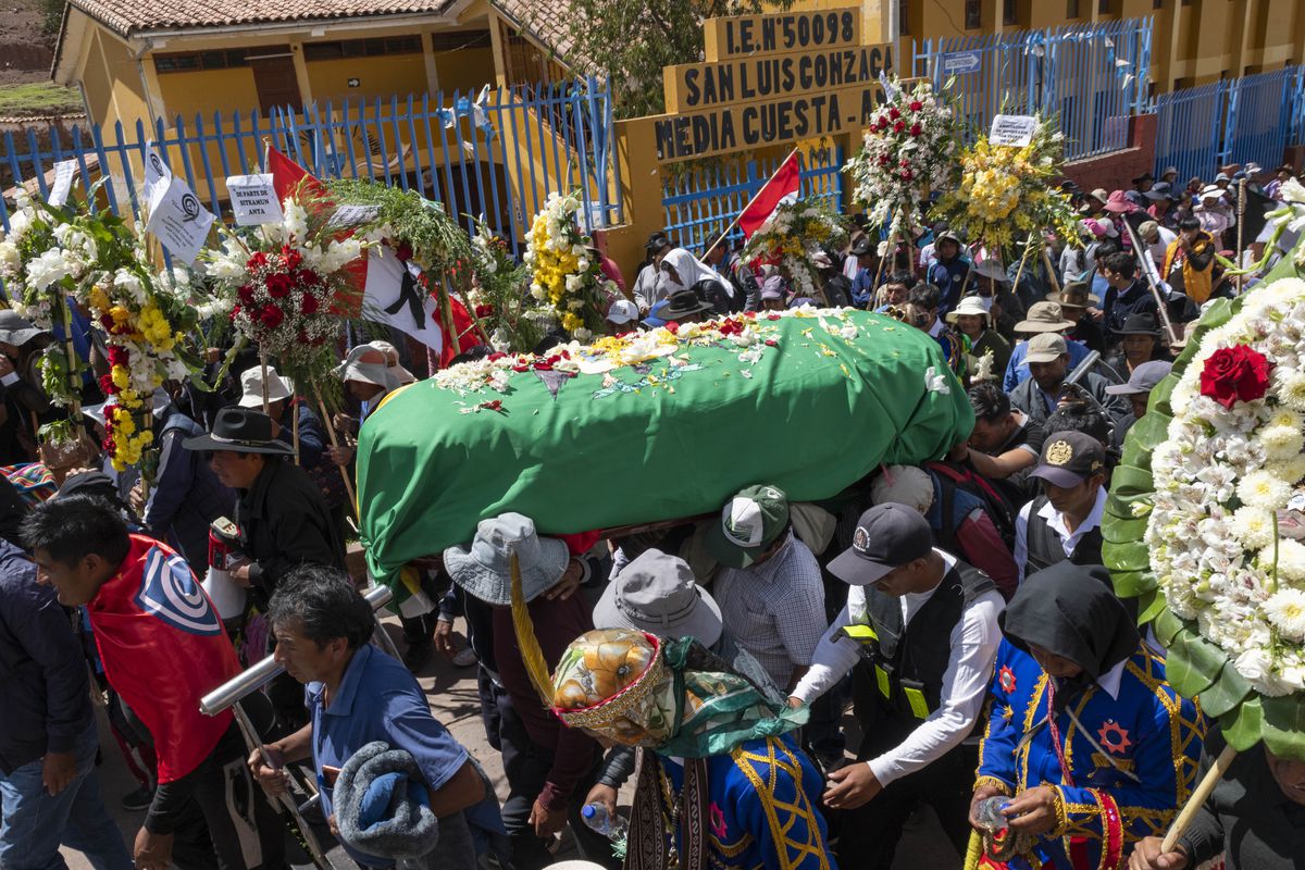 Pallbearers carry coffin amid crowd of mourners in funeral for Anta community leader Remo Candia Guevara, killed in protest.