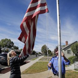 Twins Donald Dunn and Deanna Golden take down the flag at their parents' home Monday, Oct. 7, 2013. Their parents, Jerry and Edith Dunn, were born the same year and died within hours of each other.