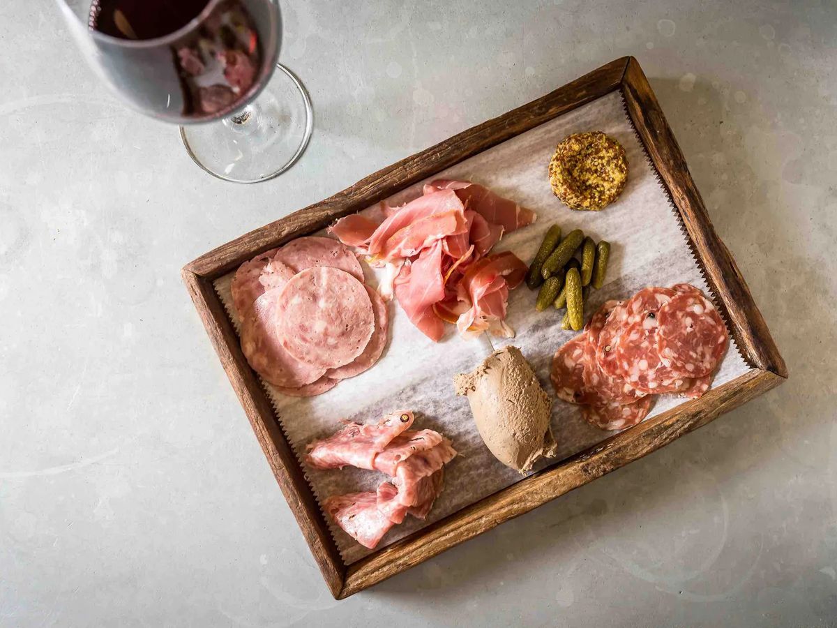 A meat board and a glass of read wine.