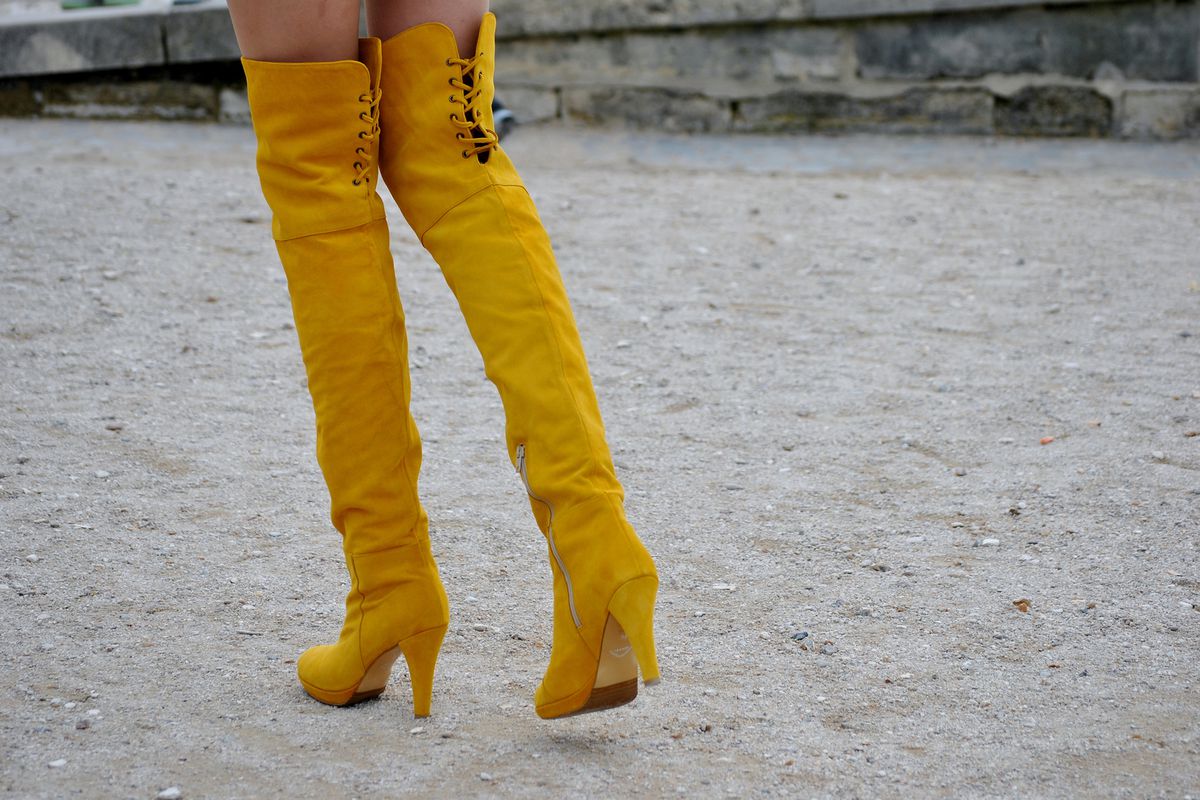 A woman in high mustard suede boots