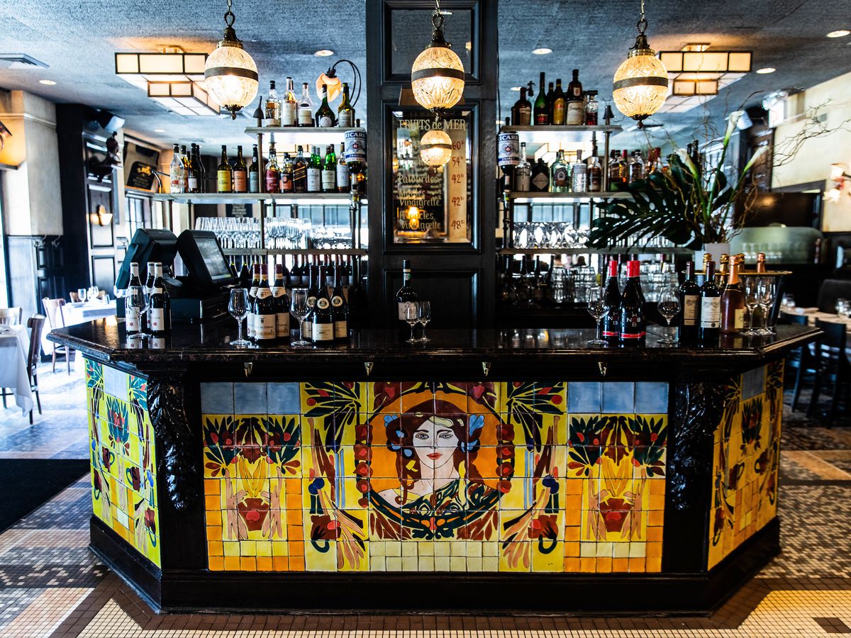 A restaurant bar decorated with tiles that form a woman’s face.