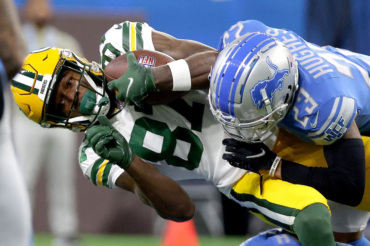 Romeo Doubs #87 of the Green Bay Packers gets tackled by Mike Hughes #23 of the Detroit Lions in the first quarter at Ford Field on November 06, 2022 in Detroit, Michigan.