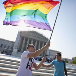 Vin Testa of Washington waves a rainbow flag in support of gay rights outside the Supreme Court in Washington, Tuesday, June 25, 2013, as key decisions are expected to be announced. The Supreme Court resolved five cases, including affirmative action, on Monday. That leaves disputes about gay marriage and voting rights among the six remaining cases. The justices are meeting again Tuesday to issue some opinions and will convene at least one more time.
