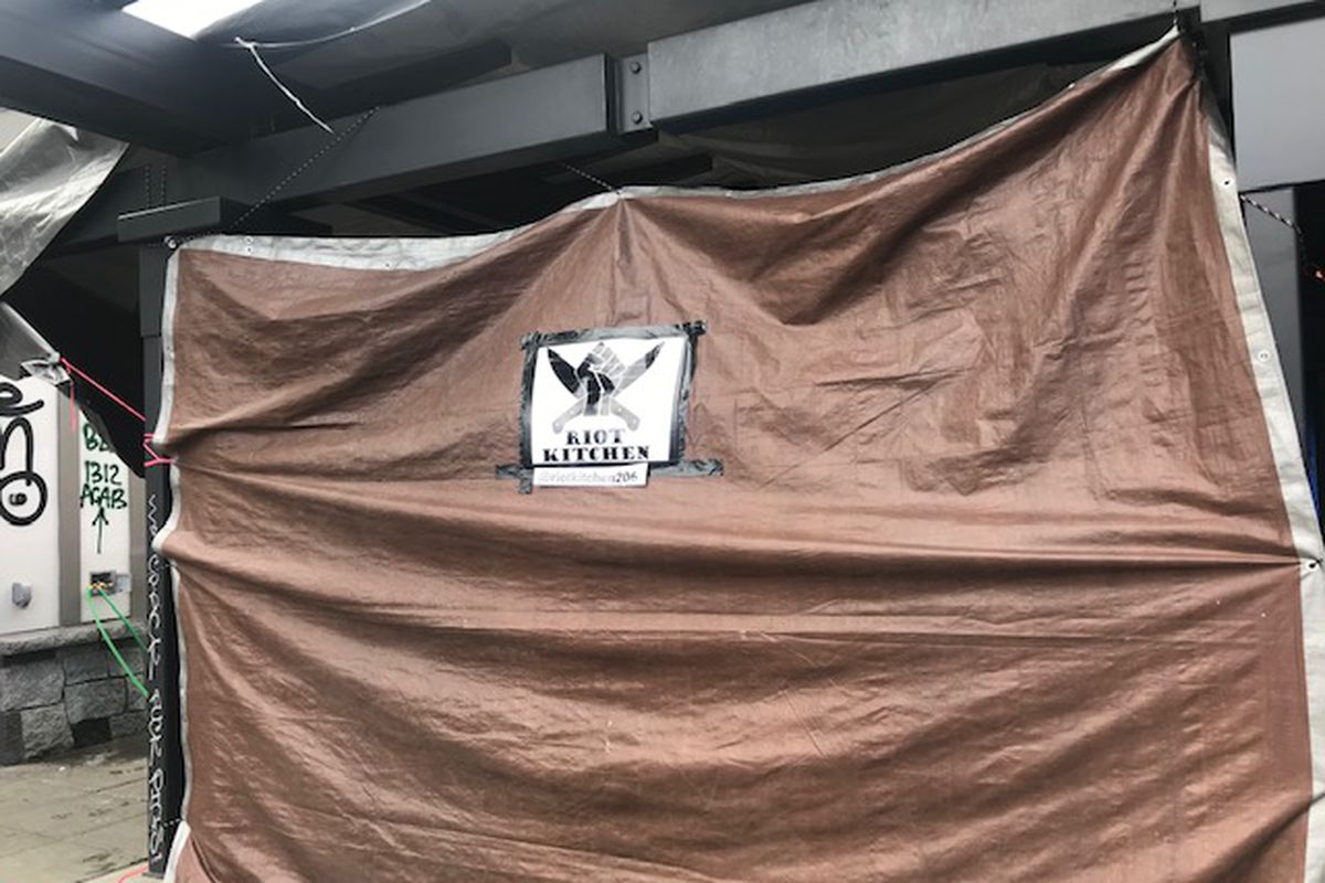 A tan tarp that displays the Riot Kitchen logo